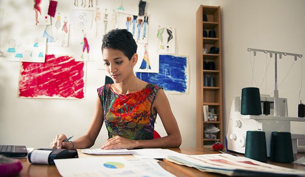 hispanic woman doing budget in fashion designer atelier